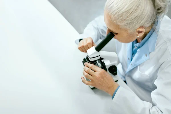 Laboratuar araştırmaları. Kadın bilim adamı kullanma mikroskop. — Stok fotoğraf