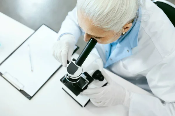Laboratory Research. Female Scientist Using Microscope.