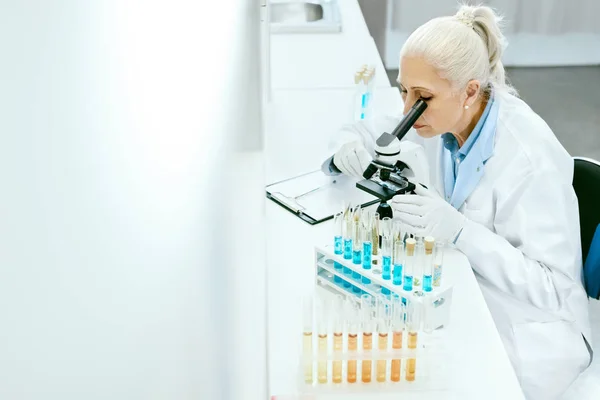 Laboratory Research. Woman Looking Through Microscope.