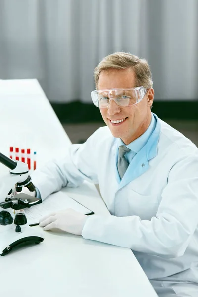 Лабораторные испытания. Мужской врач анализирует образец крови — стоковое фото
