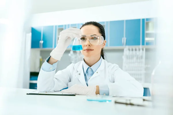 Wetenschappelijk laboratorium. Vrouwelijke wetenschapper met laboratorium glas. — Stockfoto