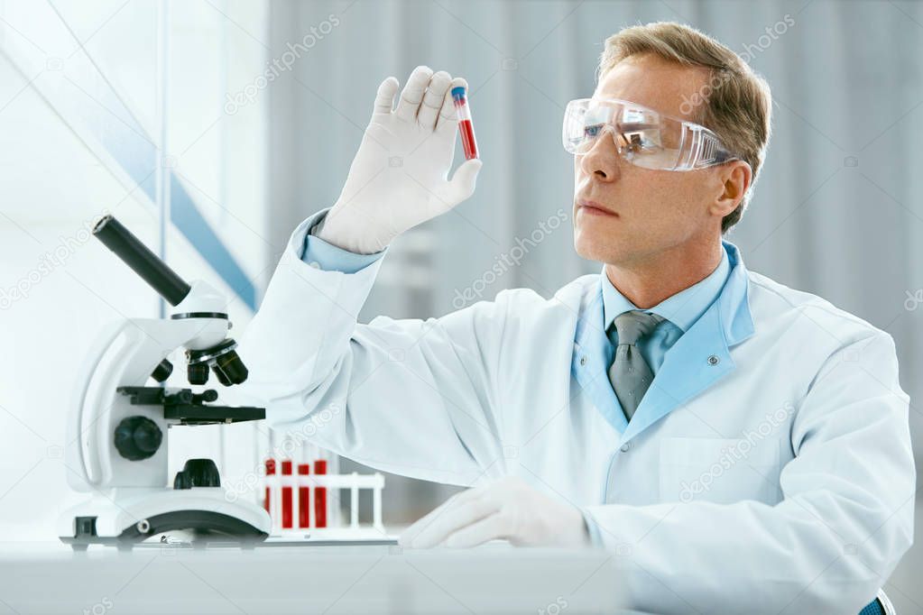Laboratory Test. Male Doctor Analyzing Blood Sample