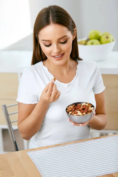 Zdravé jídlo. Šťastná žena jíst oříšky — Stock fotografie