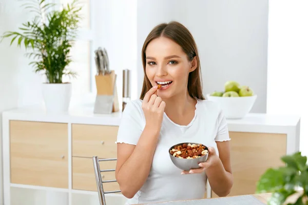 Nutrição Saudável. bela jovem mulher comer nozes — Fotografia de Stock