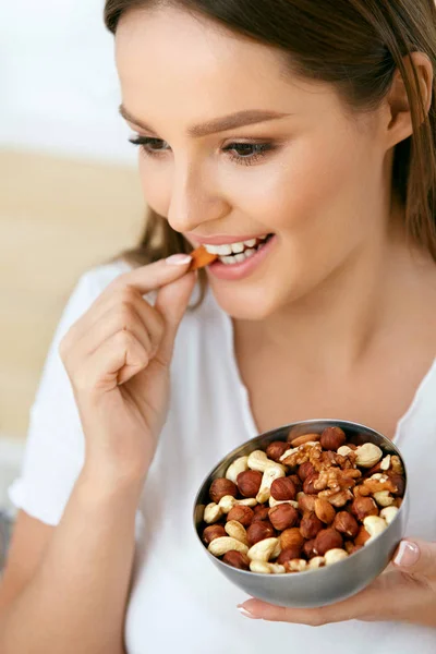 Nutrição Saudável. bela jovem mulher comer nozes — Fotografia de Stock