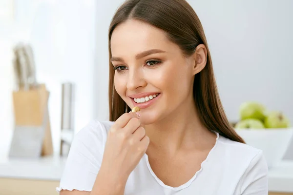 Mujer comiendo comida saludable en la cocina — Foto de Stock