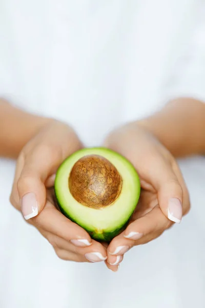 Comida saudável. Abacate em mãos de mulher — Fotografia de Stock