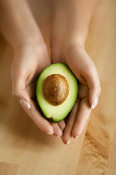 Comida saudável. Abacate em mãos de mulher — Fotografia de Stock