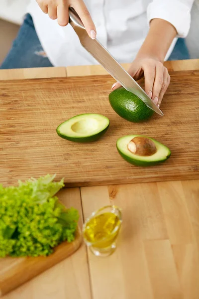 Ernährung. Weibliche Hände schneiden Avocado in Küche. — Stockfoto