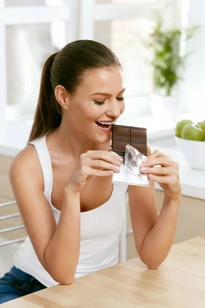 Cioccolato. Felice donna mordere cioccolato bar . — Foto Stock