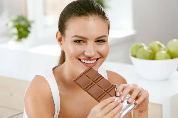 Çikolata. Mutlu kadın ısırma çikolata Bar. — Stok fotoğraf