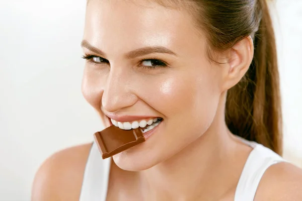 Mulher a comer chocolate. Menina bonita com doces . — Fotografia de Stock