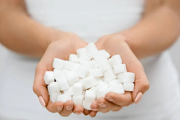 Frauenhände mit Zuckerwürfeln. — Stockfoto