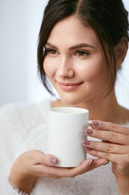 Kahve içecek. Güzel erkek fincan sıcak bir içecek ile tutarak.