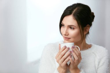 İç. Güzel kadın çay bardağı içme