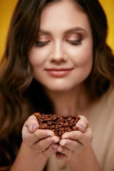 Granos de café. Hermosa mujer oliendo granos de café — Foto de Stock