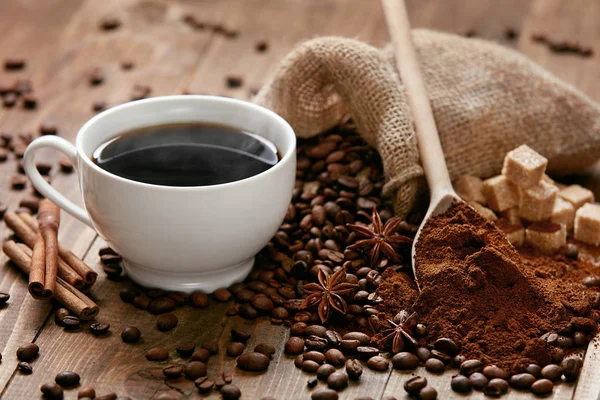 Чашка кави та кавових зерен на столі . — стокове фото