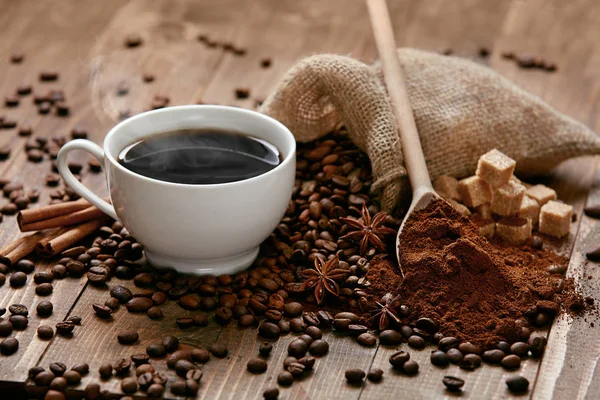 Filiżanka kawy i ziaren kawy na stole. — Zdjęcie stockowe