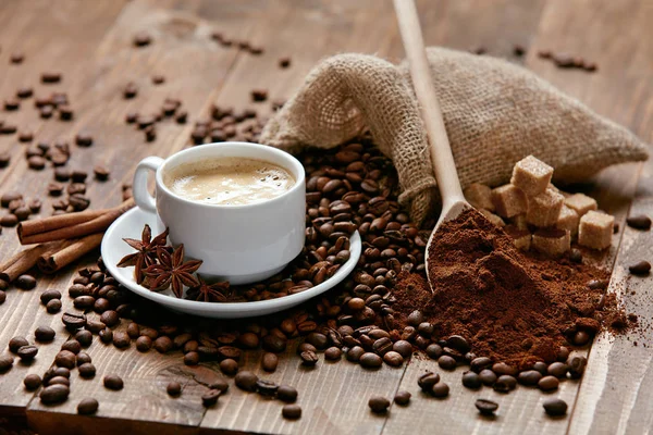 Taza de café y granos de café en la mesa. — Foto de Stock