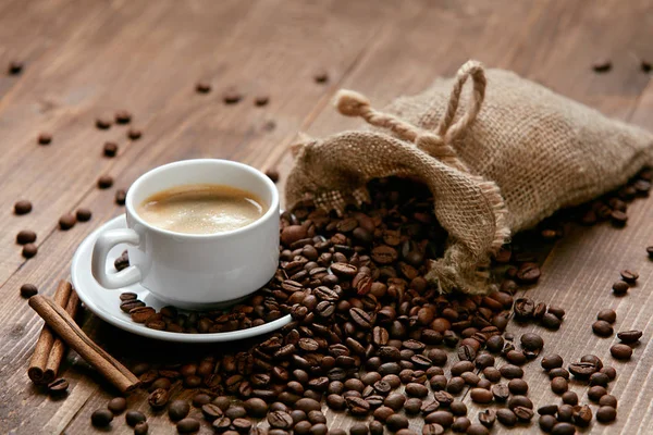 Xícara de café e grãos de café na mesa. — Fotografia de Stock