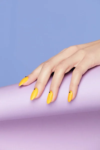 Desenho de unhas. Mãos com manicure amarelo brilhante — Fotografia de Stock
