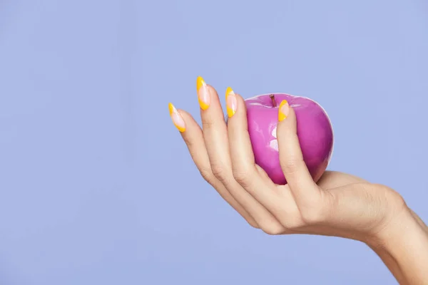 Nails Design. Kobiecych rąk z kolorowe paznokcie trzyma jabłko — Zdjęcie stockowe