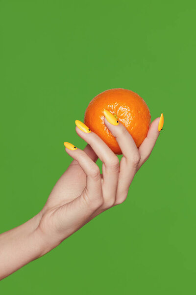 Nails Design. Hands With Fashion Manicure Holding Orange