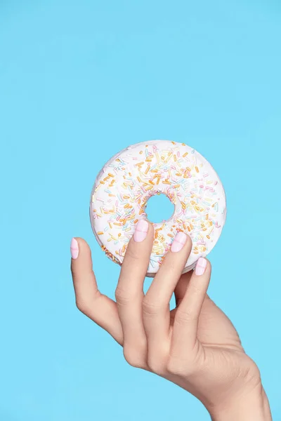 Manicure. Mão com unhas pastel segurando Donut — Fotografia de Stock