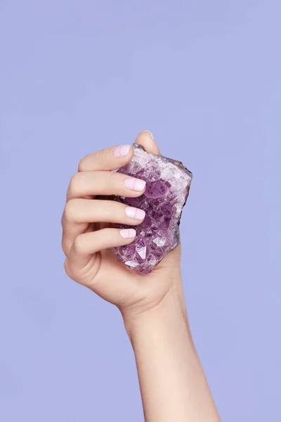 Manicura. Mano con uñas elegantes sosteniendo la piedra preciosa púrpura — Foto de Stock