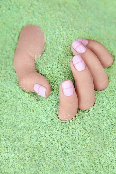 Cuidado con las manos. Mano con uñas de pastel en sal marina — Foto de Stock