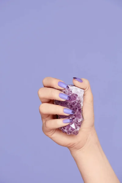 Manicura. Mano con uñas elegantes sosteniendo la piedra preciosa púrpura —  Fotos de Stock