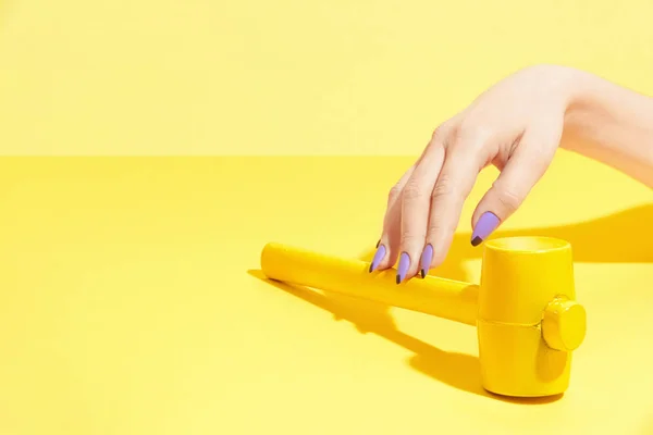 Nageldesign. Hand mit bunten Nägeln auf gelbem Hintergrund — Stockfoto