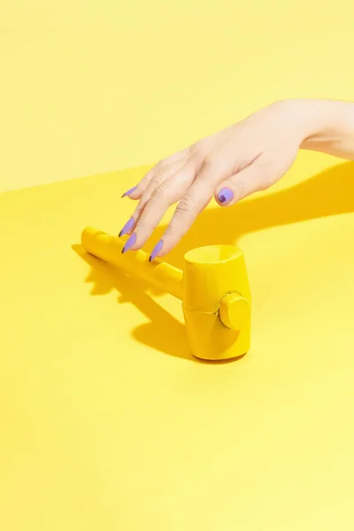 Nail Design. Kéz-és a sárga háttér színes körmök — Stock Fotó
