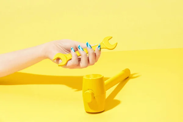Nail Design. Kéz-és a sárga háttér színes körmök — Stock Fotó