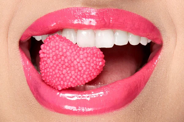 粉红色的嘴唇。嘴里有糖果的女人. — 图库照片