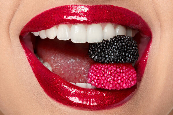 Red Lips With Glitter Lipstick And Candy In White Teeth