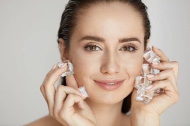 Skin Beauty Care. Woman Using Ice For Face Spa Treatment clipart