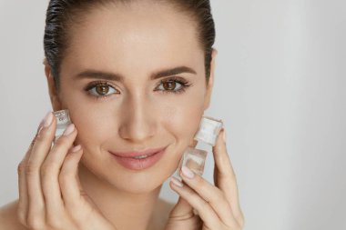 Ice On Skin. Woman Doing Face Skin Treatment clipart