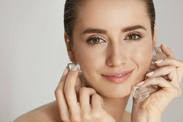 De zorg van de schoonheid van de huid. Vrouw met behulp van ijs voor gezicht spabehandeling — Stockfoto