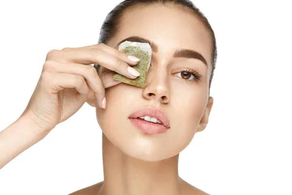 Augenpflege. schöne Frau mit grünem Teebeutel unter den Augen — Stockfoto