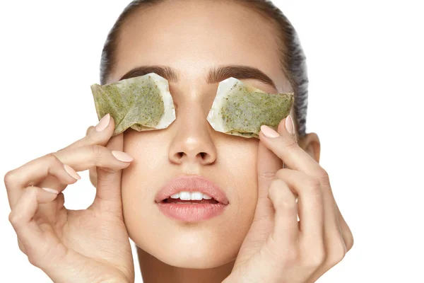 Cura della pelle degli occhi. Bella donna con sacchetto di tè verde sotto gli occhi — Foto Stock