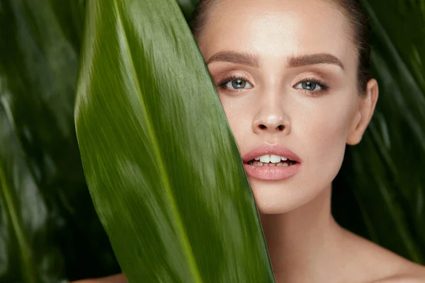 Belleza cara de mujer con piel sana y planta verde — Foto de Stock