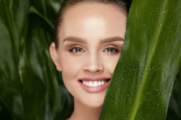 Cosméticos naturais. rosto bela mulher com planta verde — Fotografia de Stock