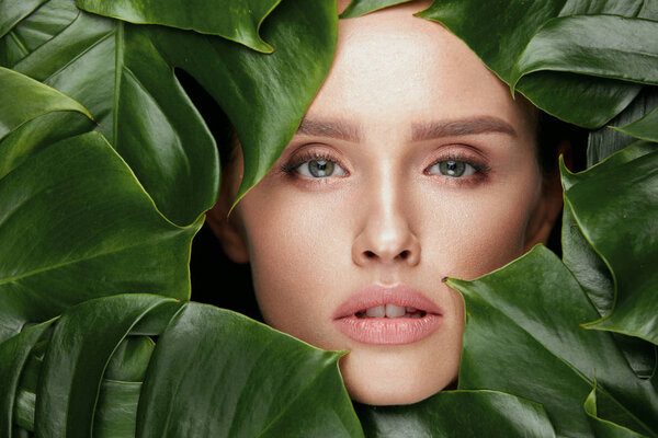 Natural Beauty. Beautiful Woman Face In Green Leaves.