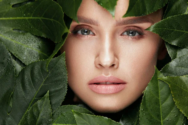 Belleza natural. Hermosa cara de mujer en hojas verdes . —  Fotos de Stock