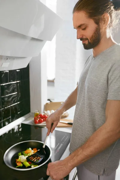 Hombre guapo cocina desayuno en casa en la cocina . —  Fotos de Stock