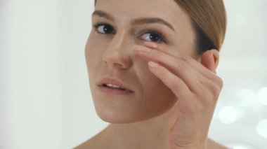 Yüz güzelliği. Orta closeup gözlerinin altında taze sağlıklı cilt masaj kadın yaşlı. Güzel Olgun kadın sevişme yüzü gözlerinin altında portresi. Kozmetik masaj. Yüksek çözünürlük