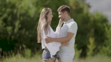 Aşk doğada kucaklayan içinde güzel bir çift. Mutlu kadın ve sarılma ve hafta sonu yaz tadını çıkarırken yakışıklı genç adam portresi. Romantik Tarih açık havada insanlar
