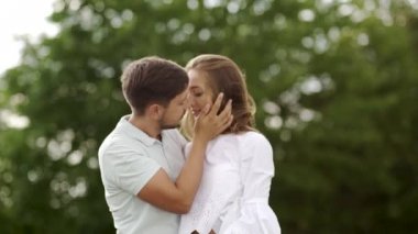 Aşk doğada kucaklayan içinde güzel bir çift. Mutlu kadın ve sarılma ve hafta sonu yaz tadını çıkarırken yakışıklı genç adam portresi. Romantik Tarih açık havada insanlar