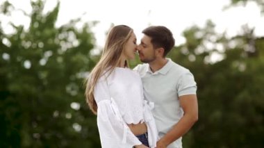 Aşk doğada kucaklayan içinde güzel bir çift. Mutlu kadın ve sarılma ve hafta sonu yaz tadını çıkarırken yakışıklı genç adam portresi. Romantik Tarih açık havada insanlar